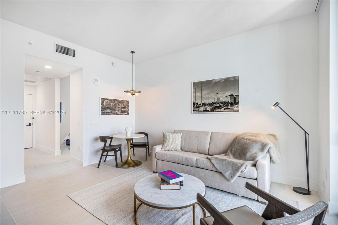 High ceilings featuring neutral wall finishes, tile flooring, and a contemporary multi-bulb pendant fixture