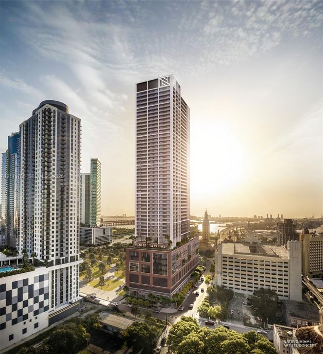 High-rise architectural structure featuring a grid-patterned glass facade, a brick-clad podium, multiple balconies, and an elevated terrace level