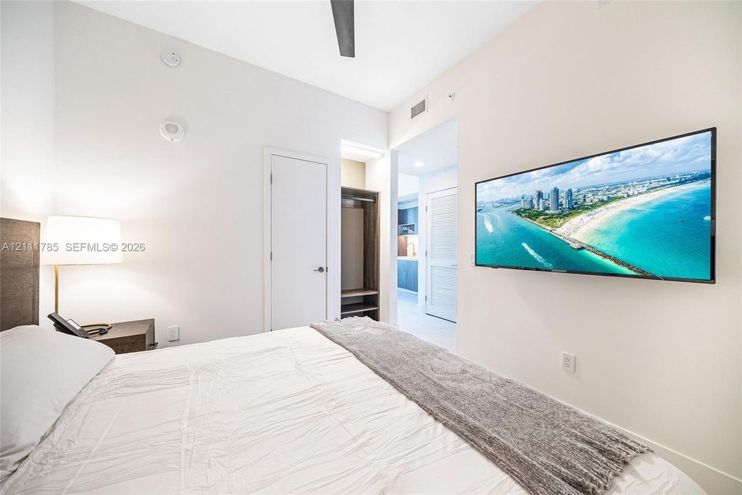 Room interior featuring high ceilings, ceiling fan, walk-in closet with built-in shelving, and recessed lighting