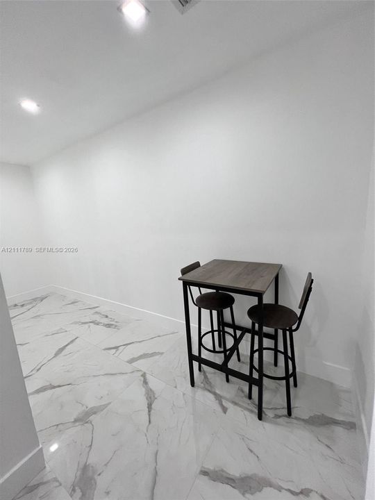 Large-format, marble-patterned tile flooring paired with recessed ceiling lighting