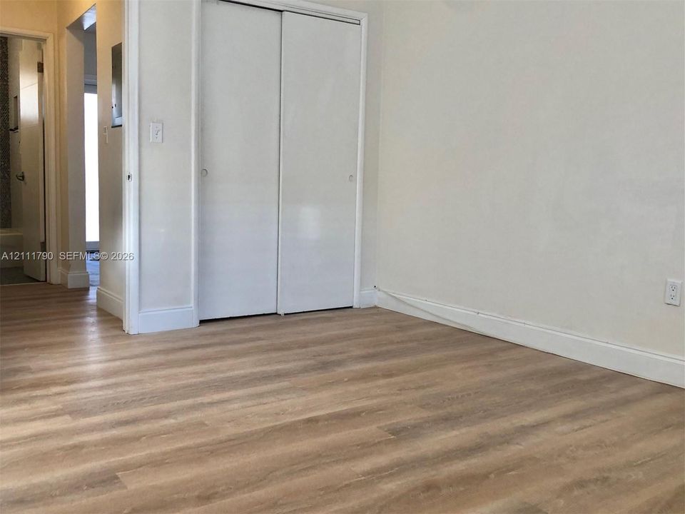 Room featuring wood-finish flooring and a dual-panel sliding closet