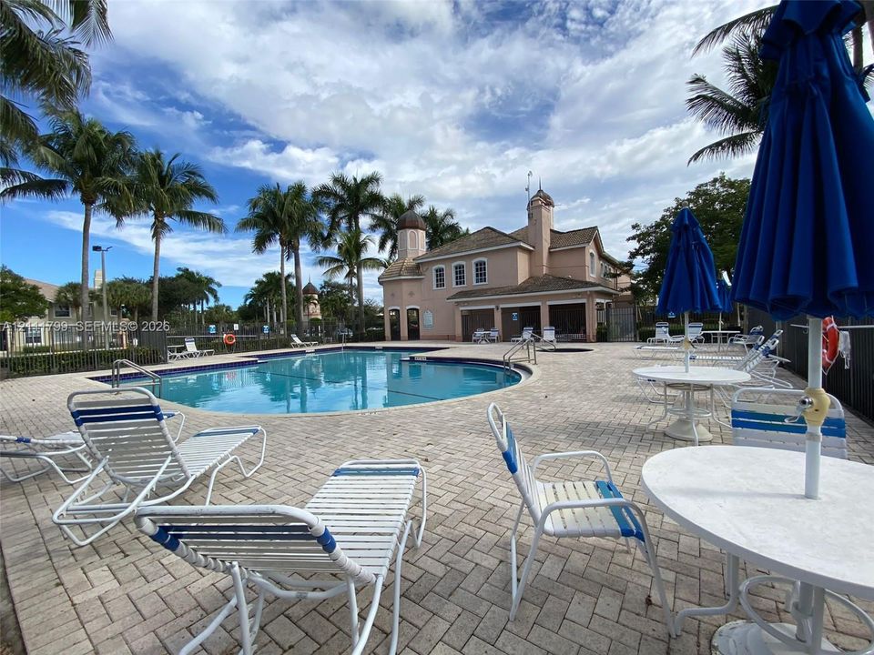 Swimming pool featuring a paver stone deck, built-in hot tub, and surrounding palm trees