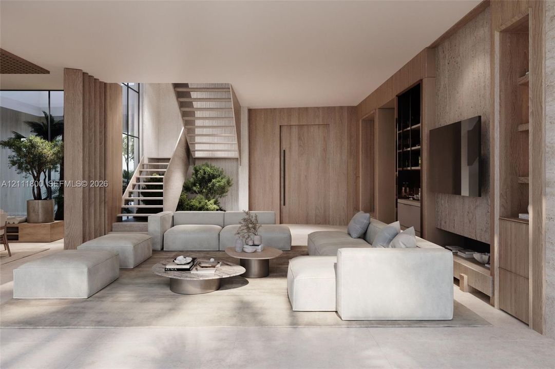 Open-concept living space featuring wood-paneled walls, floor-to-ceiling custom built-in cabinetry, an open-riser wood staircase, and expansive windows