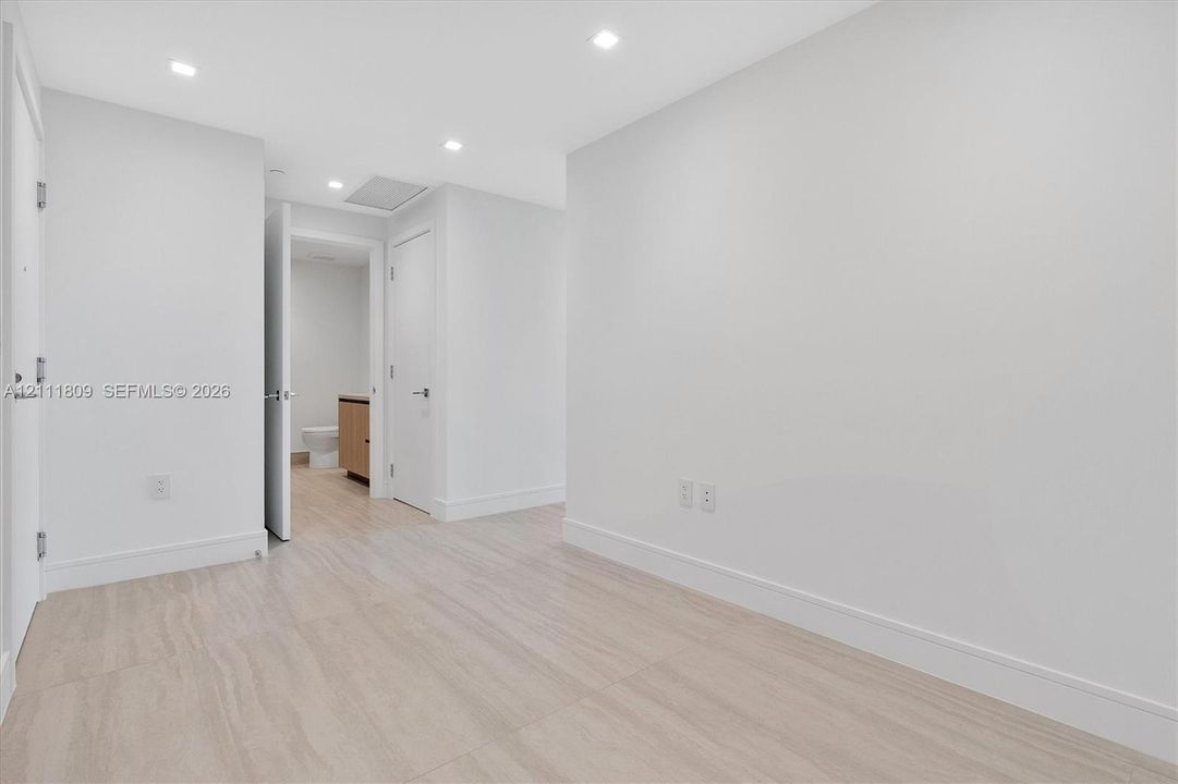 Interior space featuring neutral wall paint, wood-finish flooring, and recessed ceiling lighting