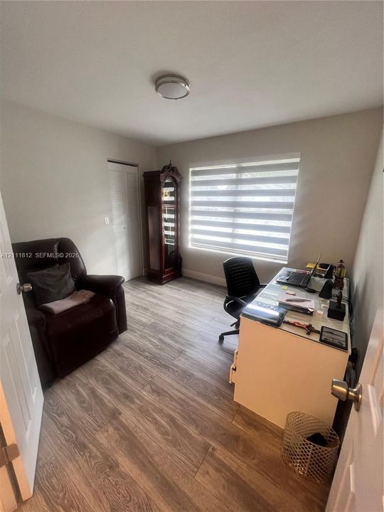 Wood-finish flooring, dual-pane horizontal window shade, and ceiling-mounted light fixture