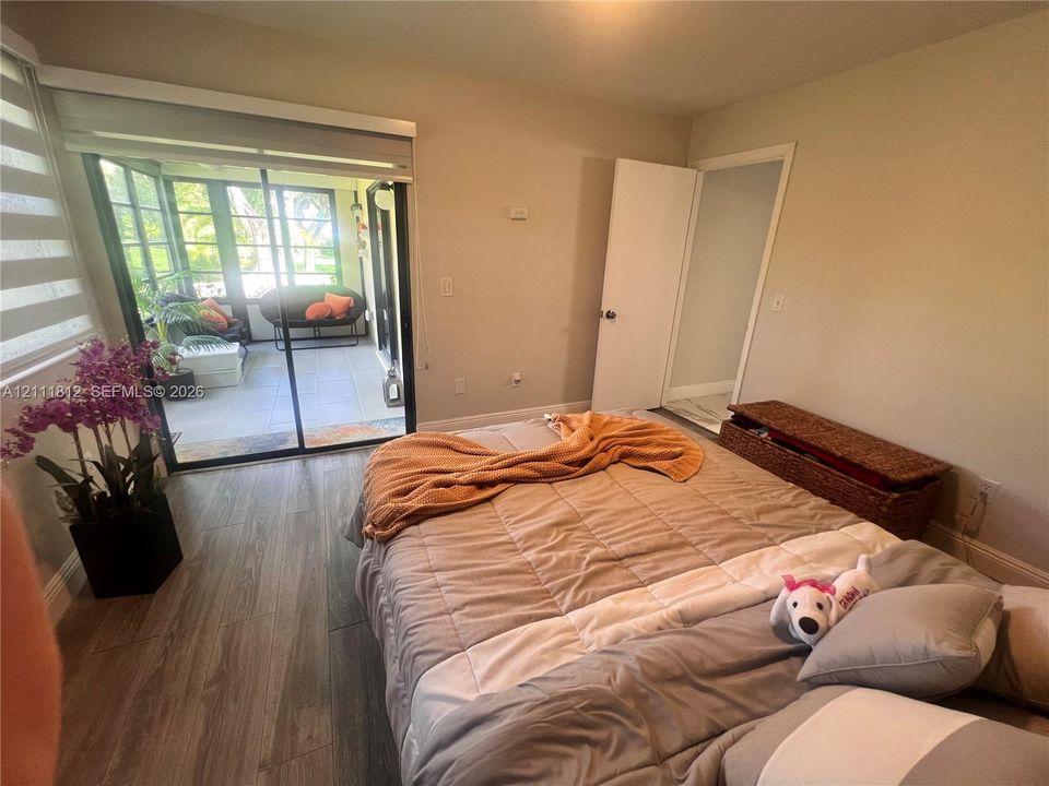 Room featuring wood-finish flooring, sliding glass doors, and a screen-enclosed patio