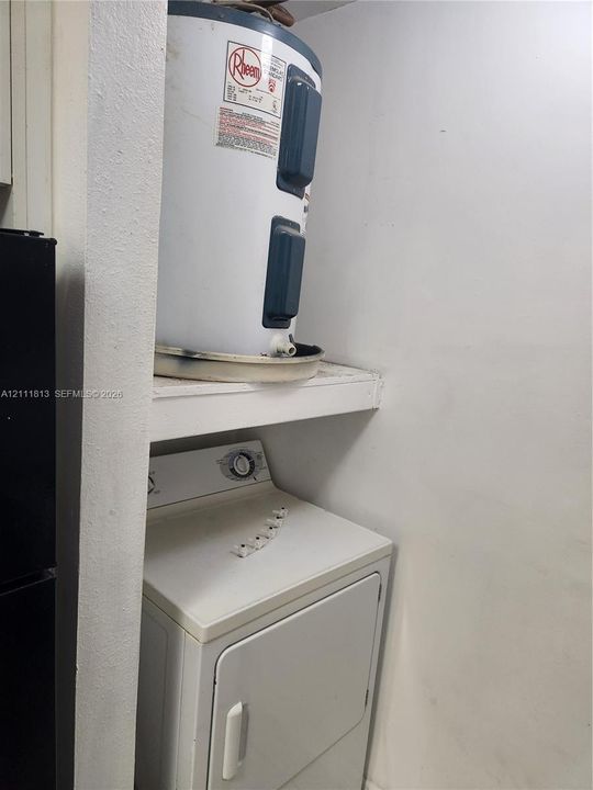 Utility closet containing a water heater and appliance storage space