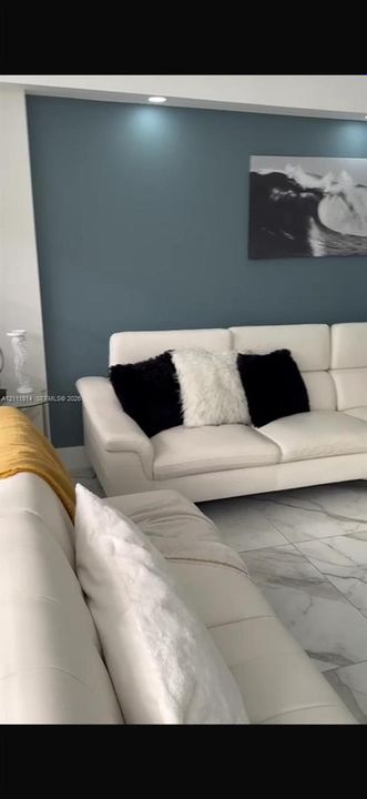 Large-format tile flooring, accent wall, and recessed ceiling lighting