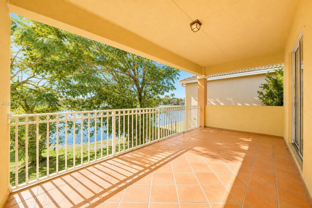 Covered balcony featuring tile flooring, white metal railing, and recessed ceiling lighting