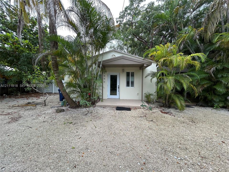 Single-story residence featuring a covered front porch, light-toned exterior finish, and gravel landscaping