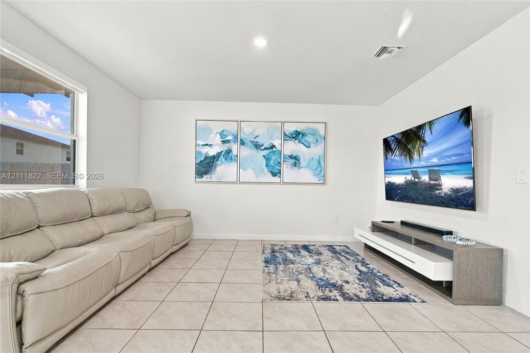 Neutral-toned ceramic tile flooring, clean white walls, and a large horizontal window