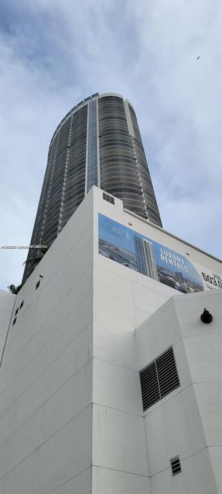 High-rise residential tower featuring a cylindrical glass facade and wraparound balconies
