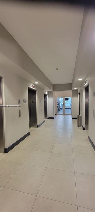 Elevator lobby featuring neutral-toned tile flooring, recessed ceiling lighting, and brushed metal elevator doors