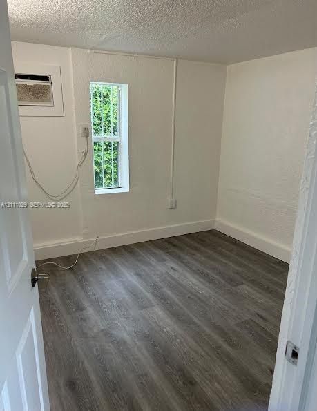 Neutral wall finish, wood-finish flooring, and a single-pane vertical window