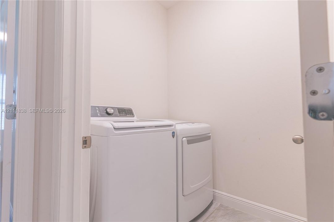Dedicated laundry area featuring neutral wall finishes and hard-surface flooring
