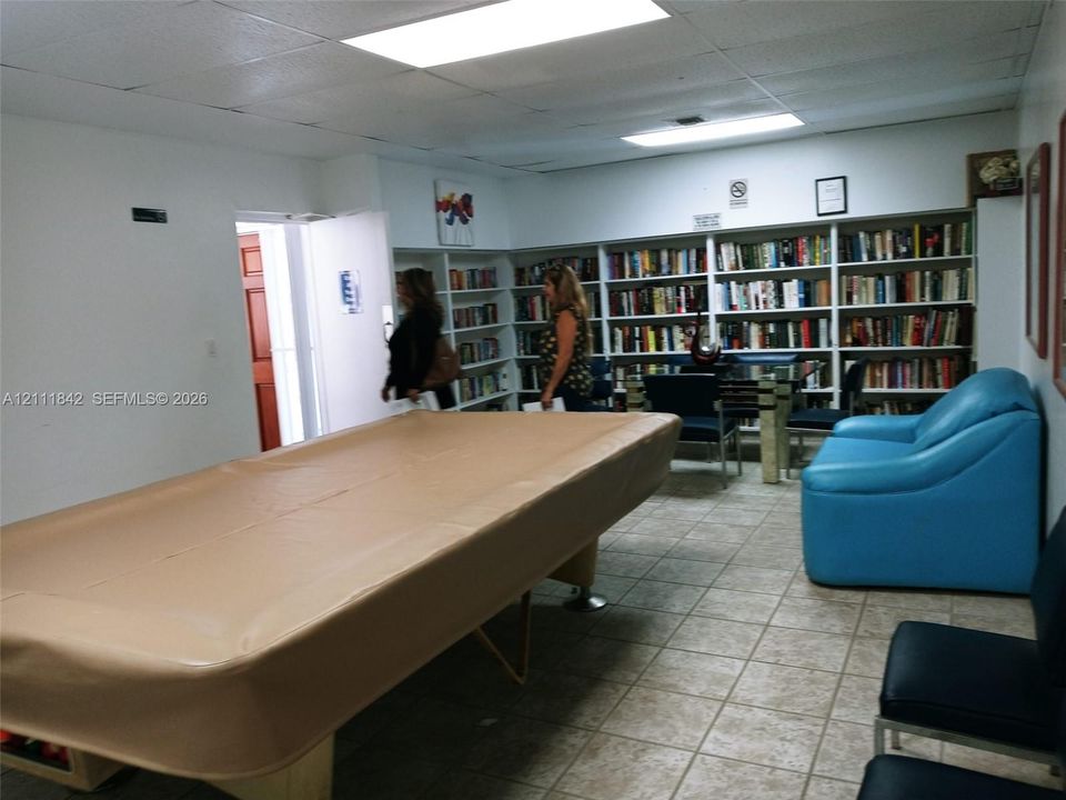 Expansive room featuring floor-to-ceiling built-in white shelving and ceramic tile flooring