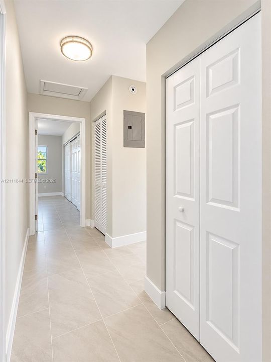 Neutral-toned tile flooring, white paneled closet doors, and recessed overhead lighting