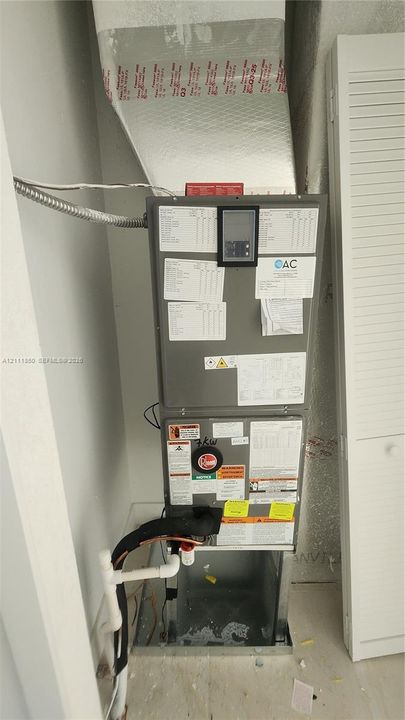 High-efficiency air handling unit featuring a digital control interface, rigid ductwork, and louvered enclosure door