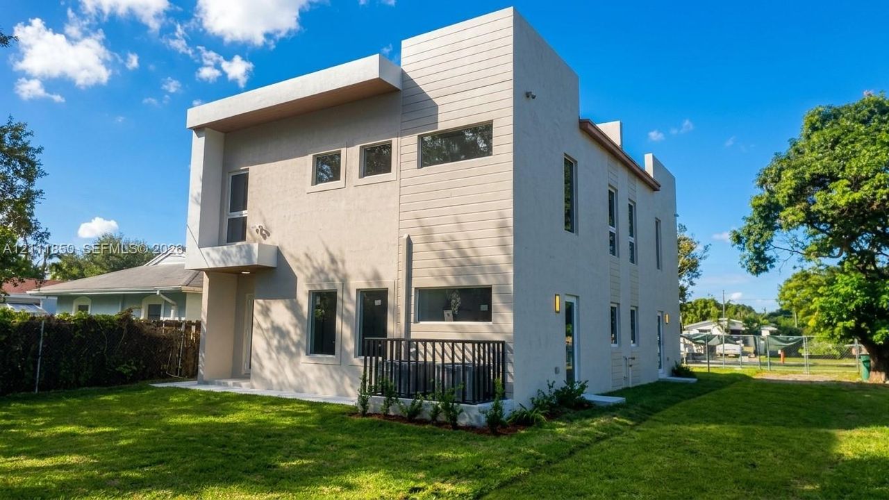 Contemporary exterior featuring smooth stucco siding, geometric architectural lines, horizontal accents, and a fenced mechanical area