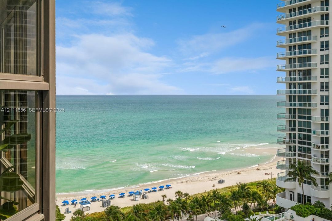 Panoramic ocean horizon with expansive coastal shoreline and high-rise balcony infrastructure