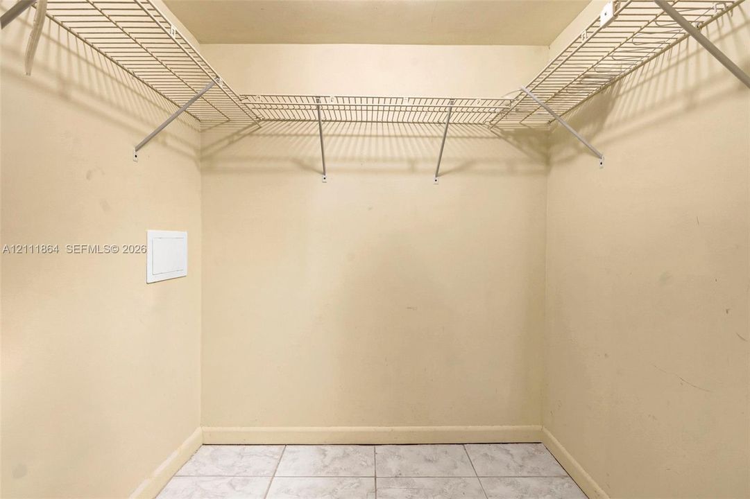 Storage area featuring white wire shelving and tile flooring