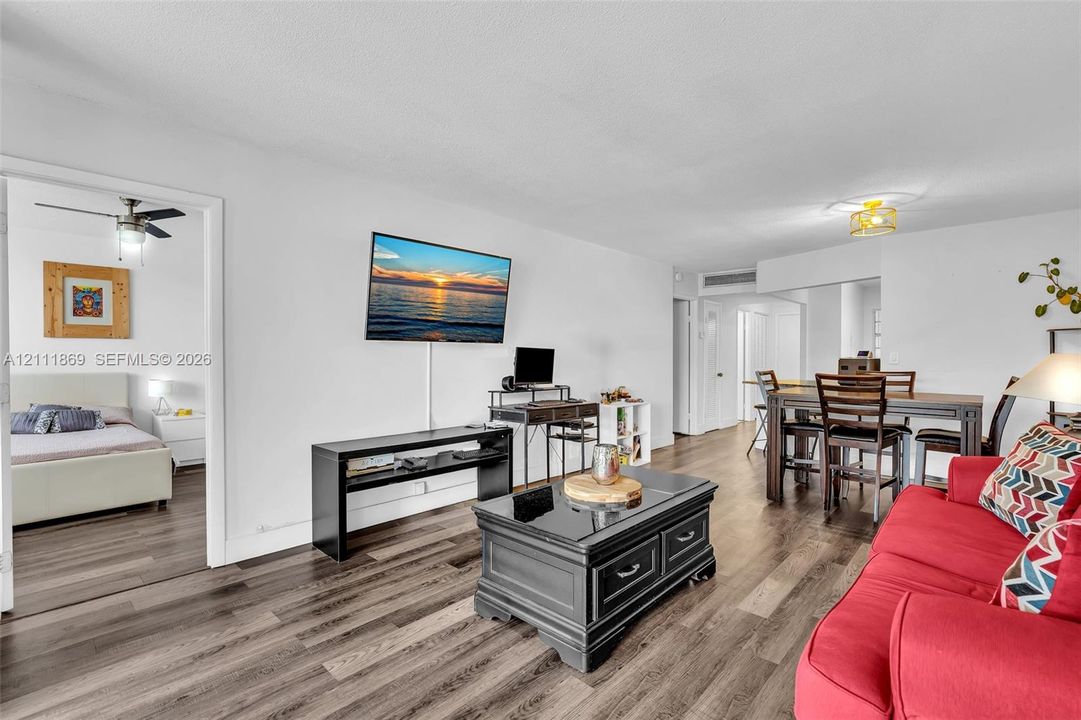 Open-concept interior featuring wood-finish flooring, neutral walls, and a ceiling-mounted light fixture