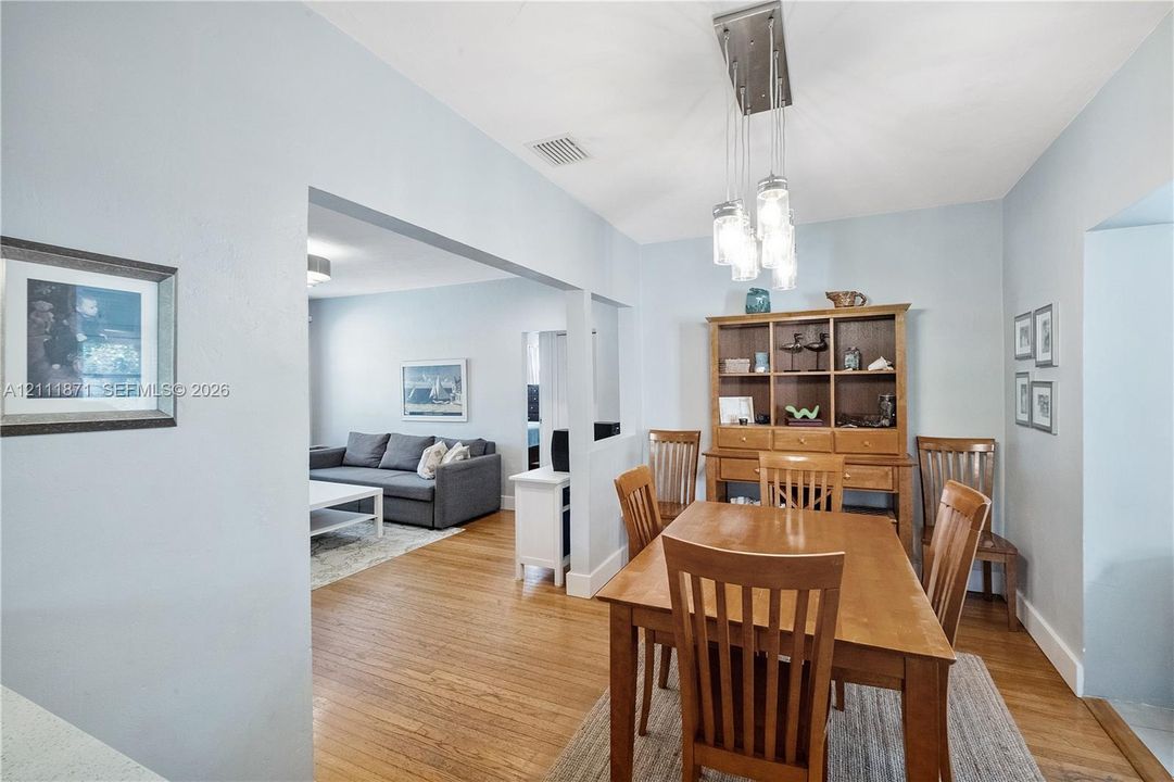 Dining area featuring wood-finish flooring and a multi-light pendant fixture