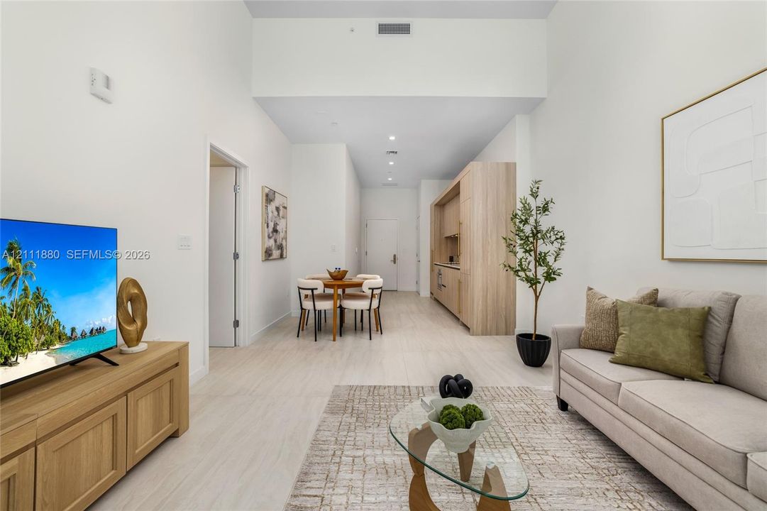 Open-concept interior featuring high ceilings, light-toned wood-finish flooring, and recessed lighting