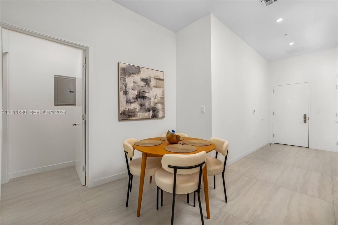 Interior space featuring high ceilings, neutral wall tones, large-format tile flooring, and recessed lighting