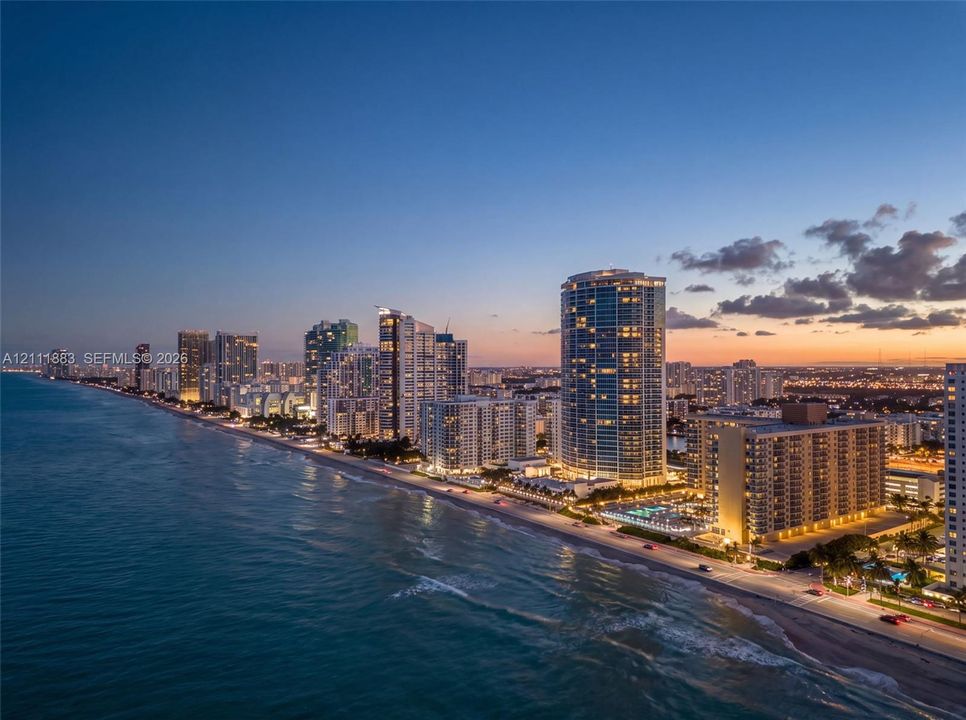 Coastal high-rise buildings situated directly along the shoreline with sandy beach access and expansive ocean horizons