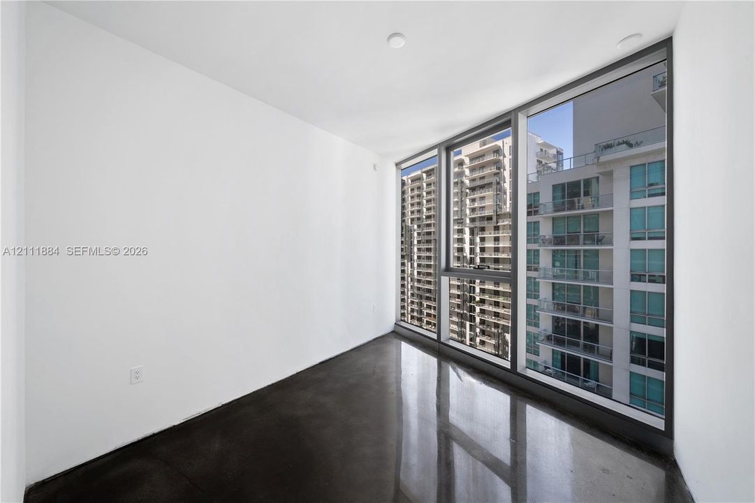 Floor-to-ceiling windows with dark metal framing and polished concrete flooring