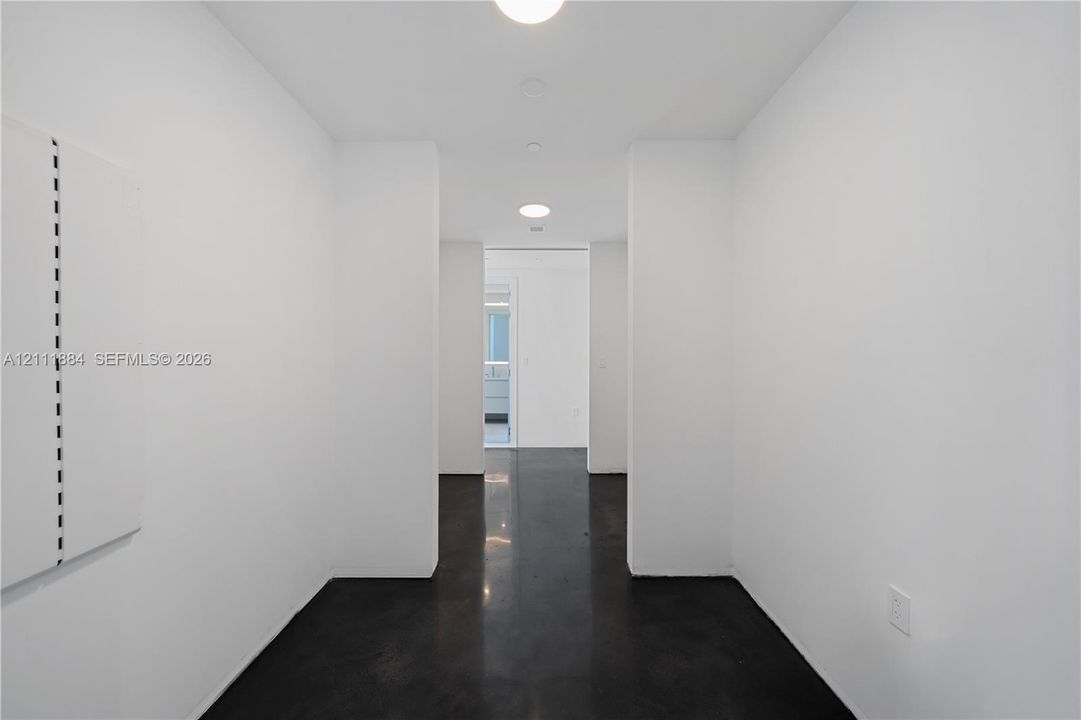 Polished concrete flooring, smooth white walls, and recessed ceiling lighting