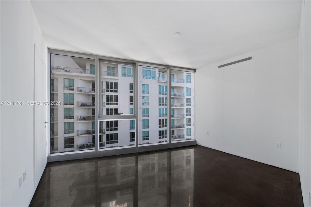 Floor-to-ceiling windows with metal framing and polished concrete flooring