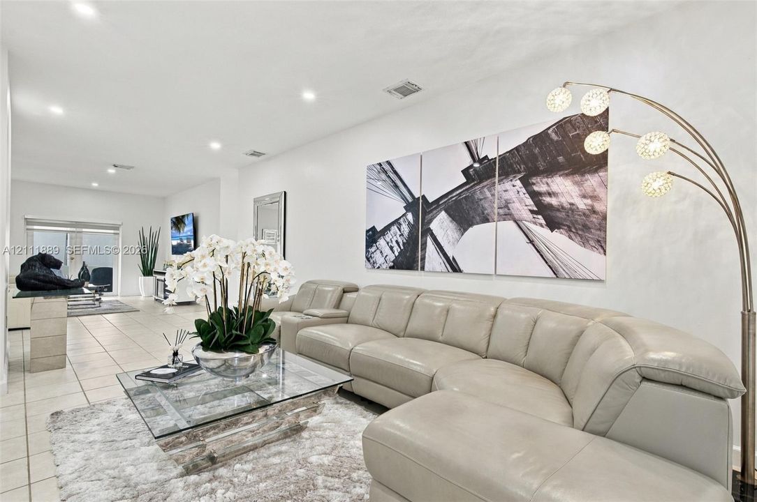 Neutral-toned tile flooring, smooth wall finishes, and recessed ceiling lighting