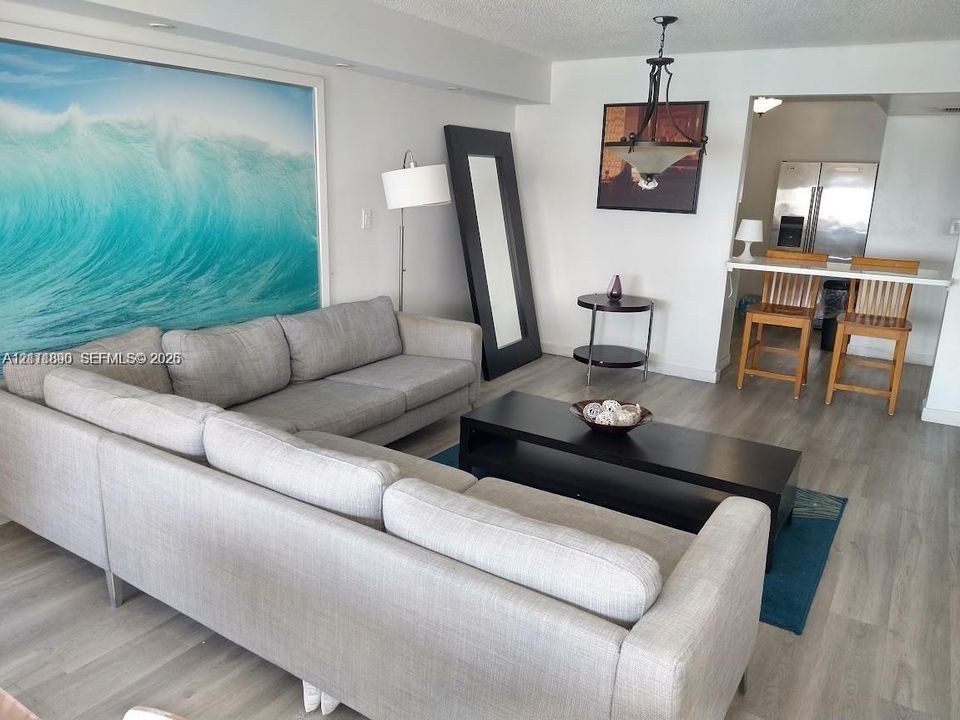 Wood-finish flooring, recessed lighting, and a suspended iron-frame light fixture
