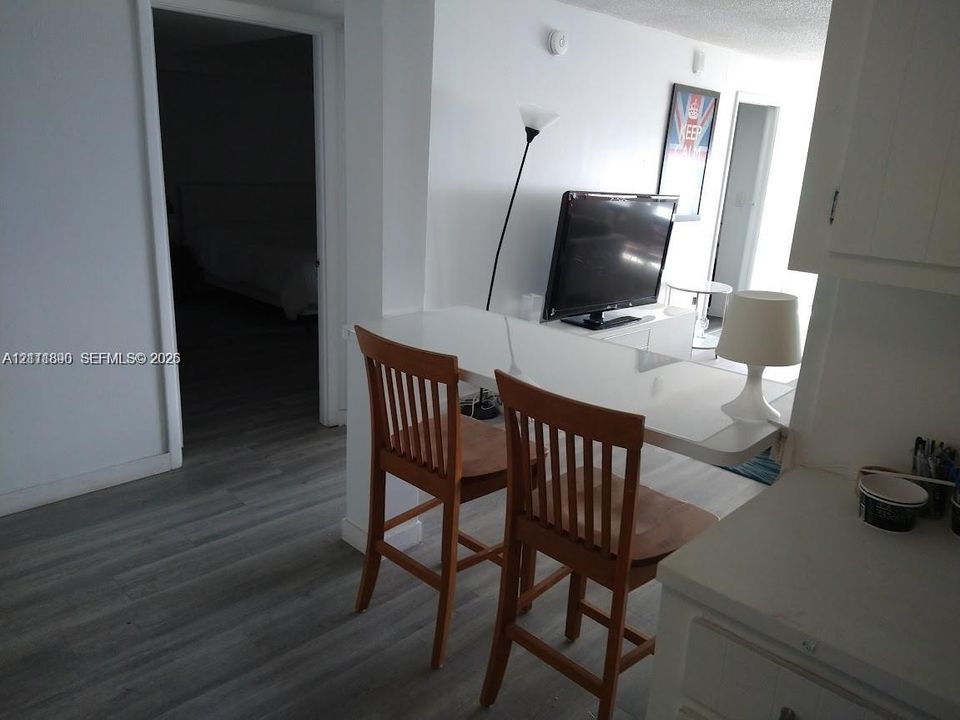 Interior featuring wood-finish flooring and a white, built-in breakfast bar
