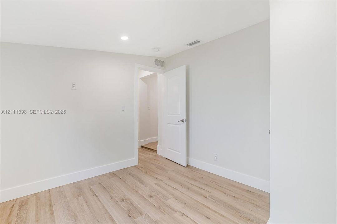 Neutral wall finishes, wood-finish flooring, and recessed ceiling lighting