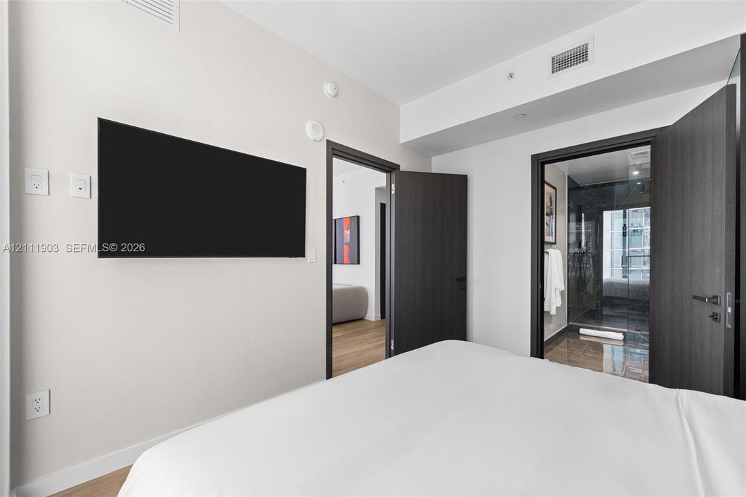 Interior room featuring dark-toned solid core doors, minimalist hardware, and wood-finish flooring