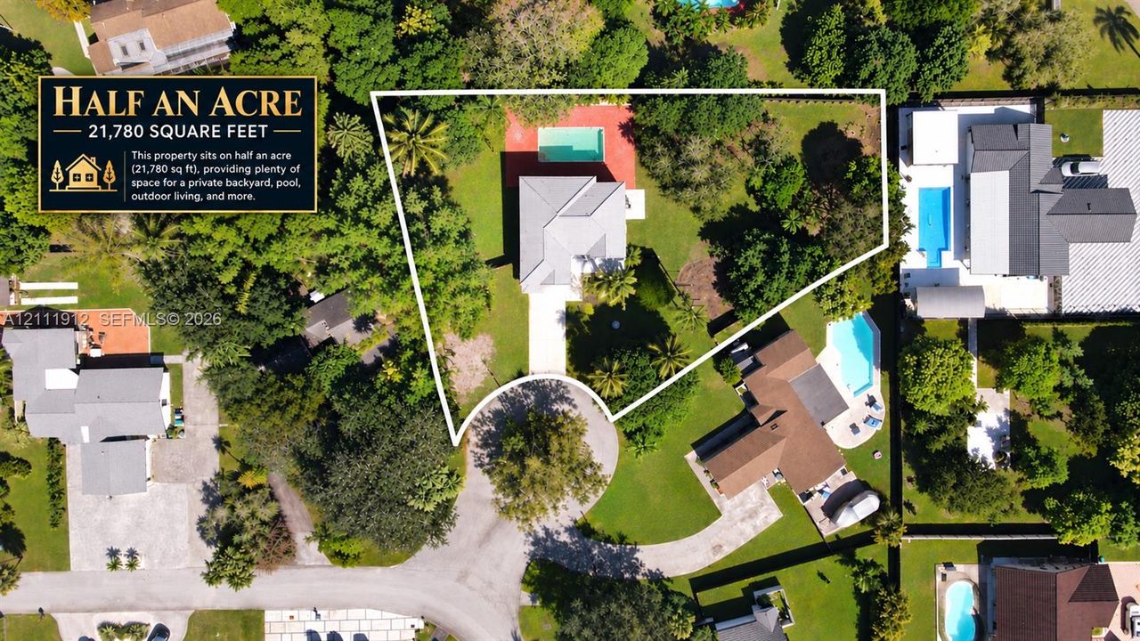 Half-acre lot featuring a swimming pool, expansive grounds, mature trees, and a concrete driveway