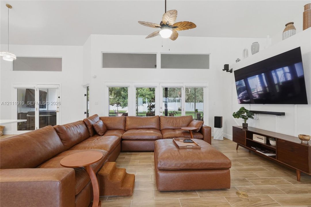 Vaulted ceilings featuring clerestory windows, tile flooring, and a ceiling fan