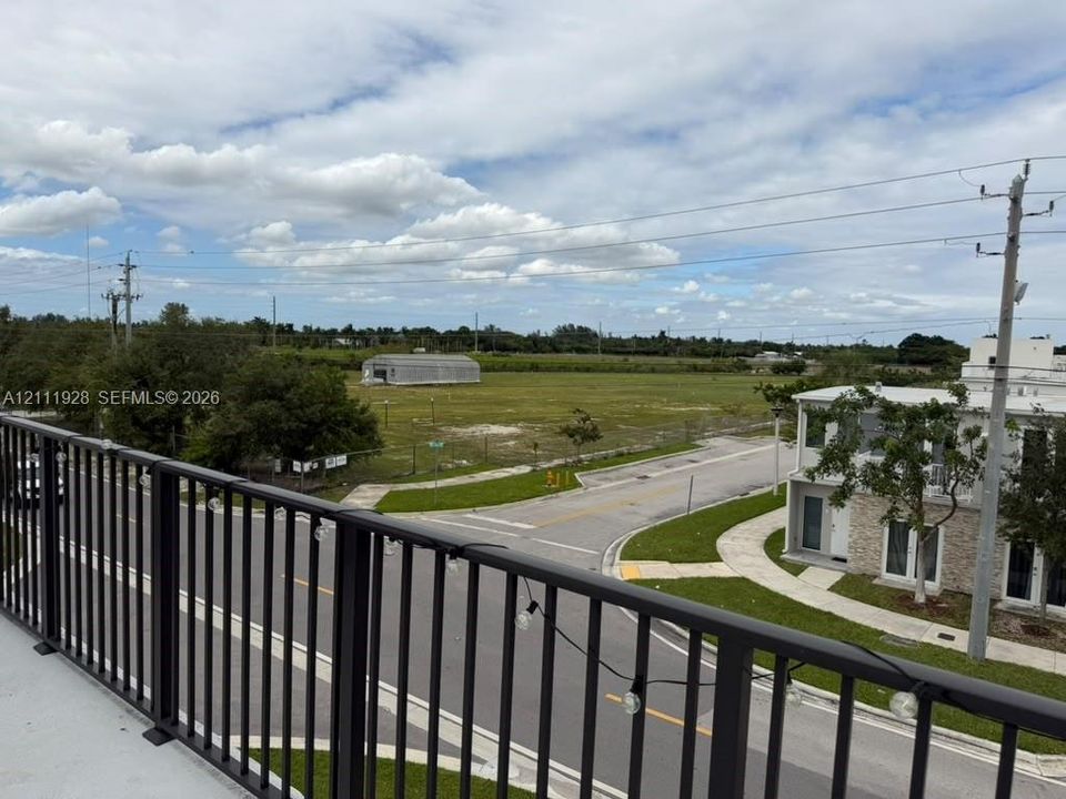 Elevated balcony with a black metal railing and expansive, open-terrain surroundings