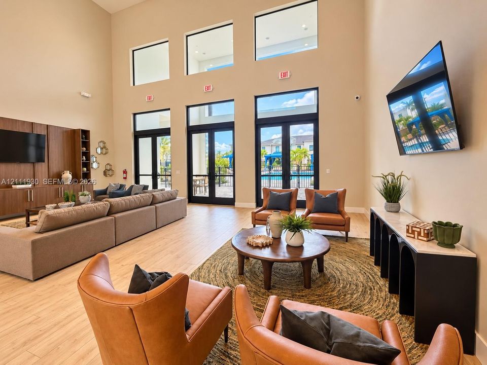 Expansive interior featuring high ceilings, multi-level windows, wood-finish flooring, and built-in floor-to-ceiling cabinetry