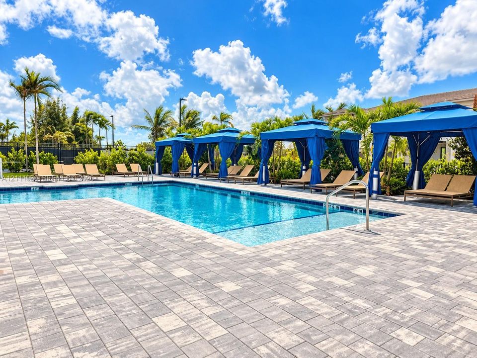 Swimming pool with paved surround and metal handrails