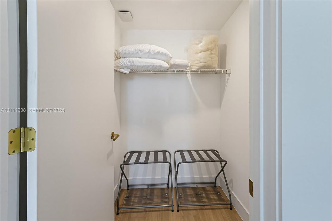 Storage space featuring wire shelving and wood-finish flooring