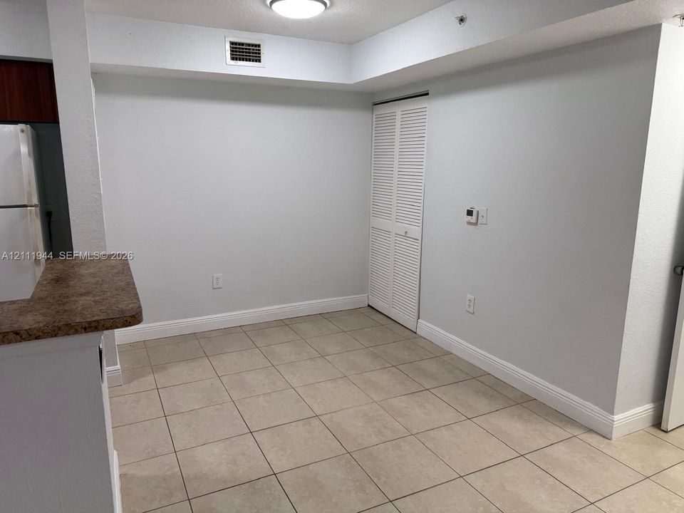 Ceramic tile flooring, neutral wall finishes, louvered closet doors, and stone-finish countertop