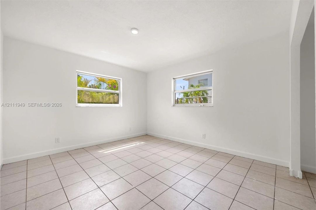 Interior room featuring neutral wall paint, tile flooring, and dual single-hung windows