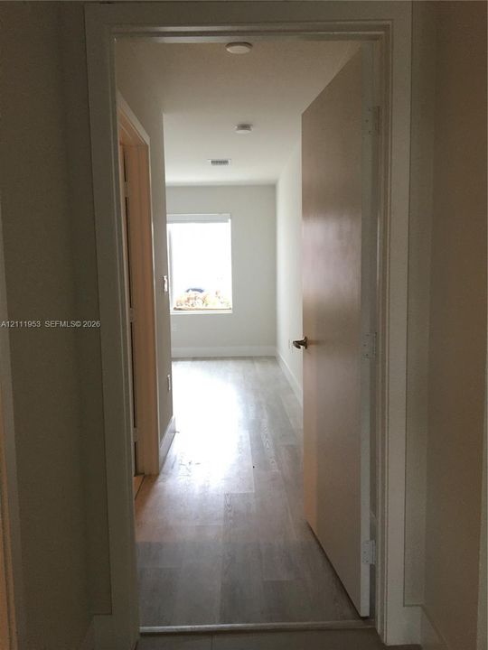 Interior space featuring wood-finish flooring, a neutral color palette, recessed lighting, and a window with natural illumination