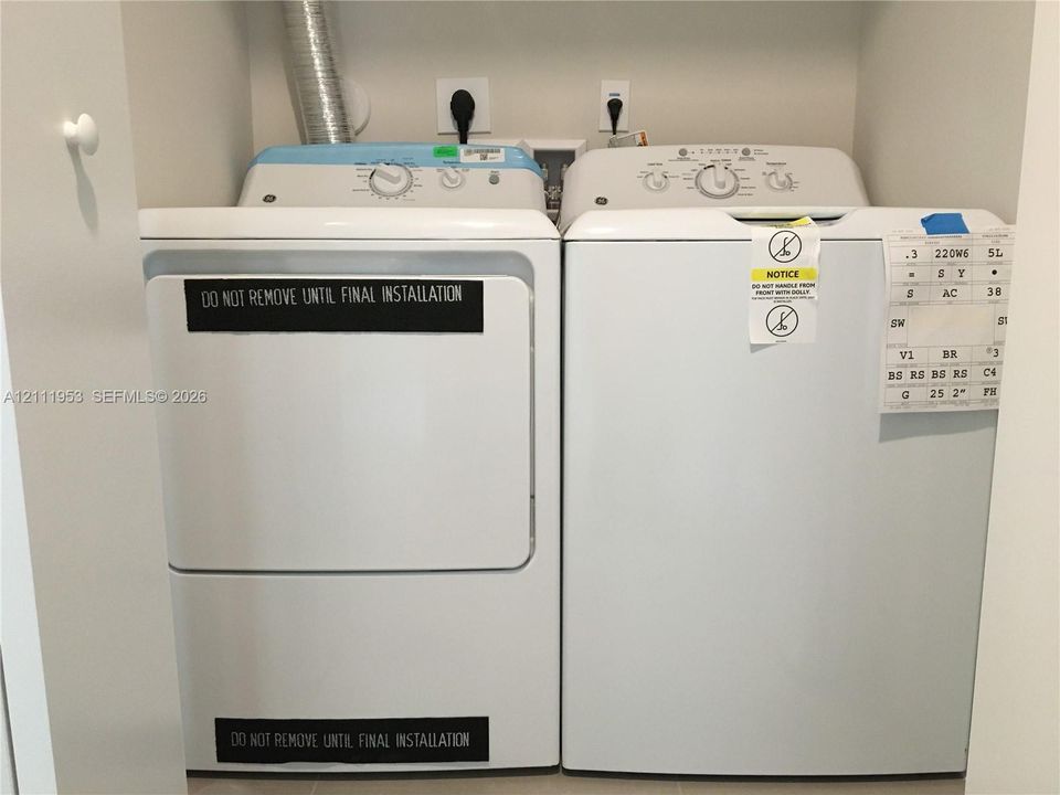 Dedicated laundry area equipped with washer and dryer hookups and recessed power outlets