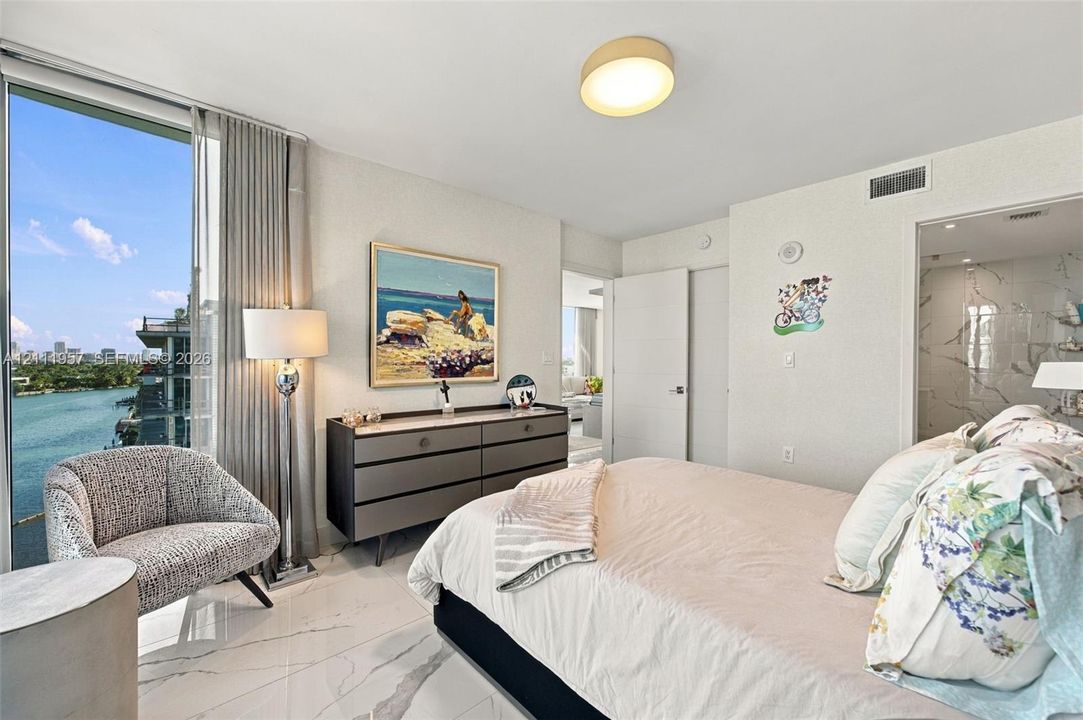 Floor-to-ceiling windows, polished stone flooring, and water scenery