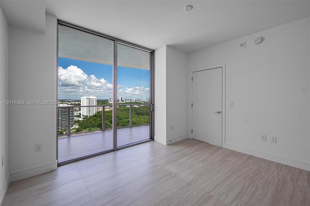 Floor-to-ceiling sliding glass doors, tiled balcony, neutral interior finish, and ceramic tile flooring